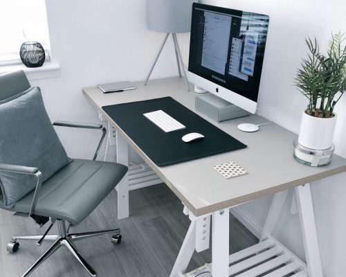 gray leather office rolling armchair beside white wooden computer desk
